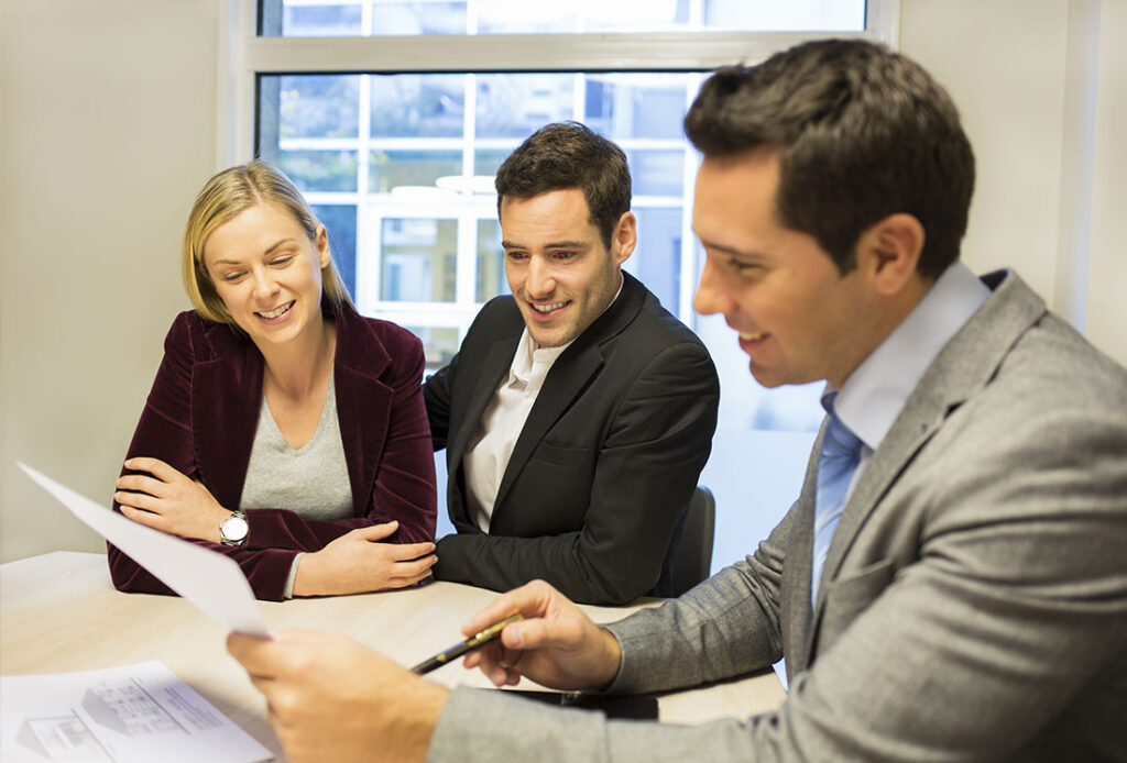 Advisor presenting documents to a couple in a meeting