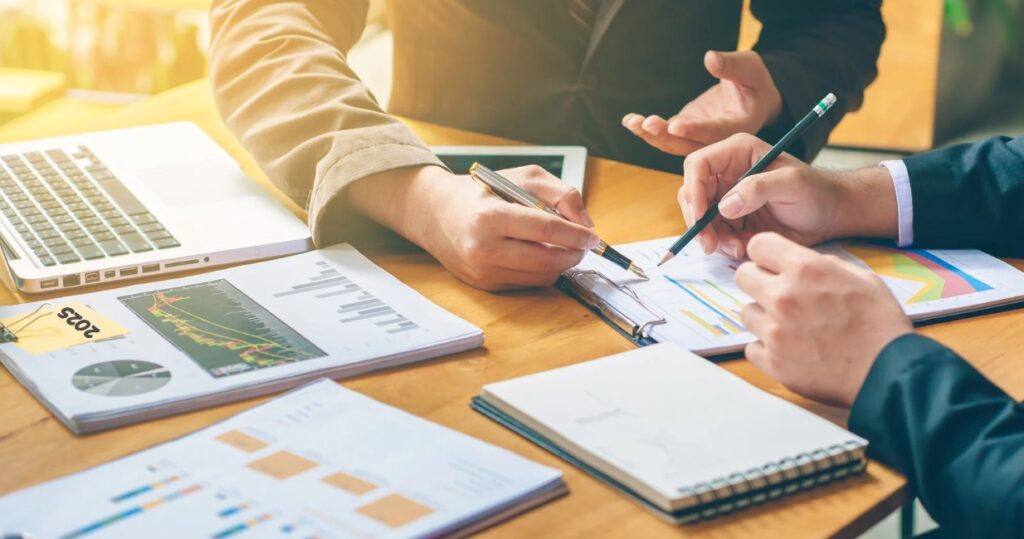 Colleagues reviewing financial charts and reports at a desk