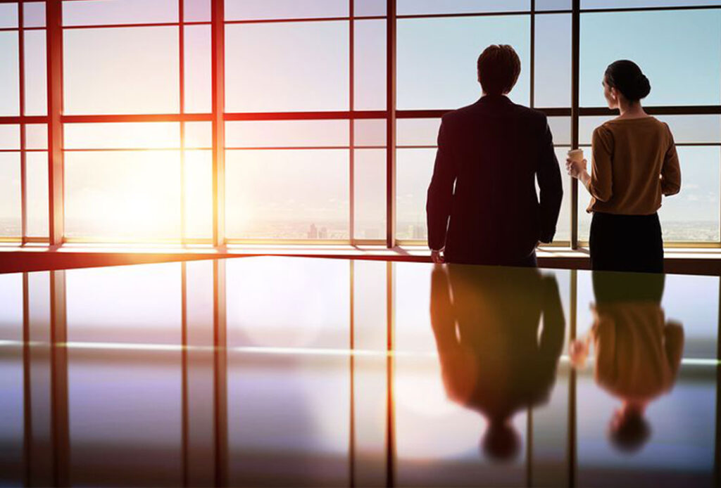 Two colleagues looking out over a city skyline