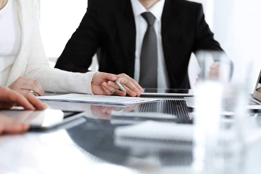 Businessman holding a pen over paperwork during a meeting