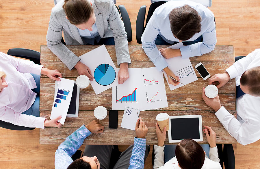 Team reviewing charts and reports together around a table