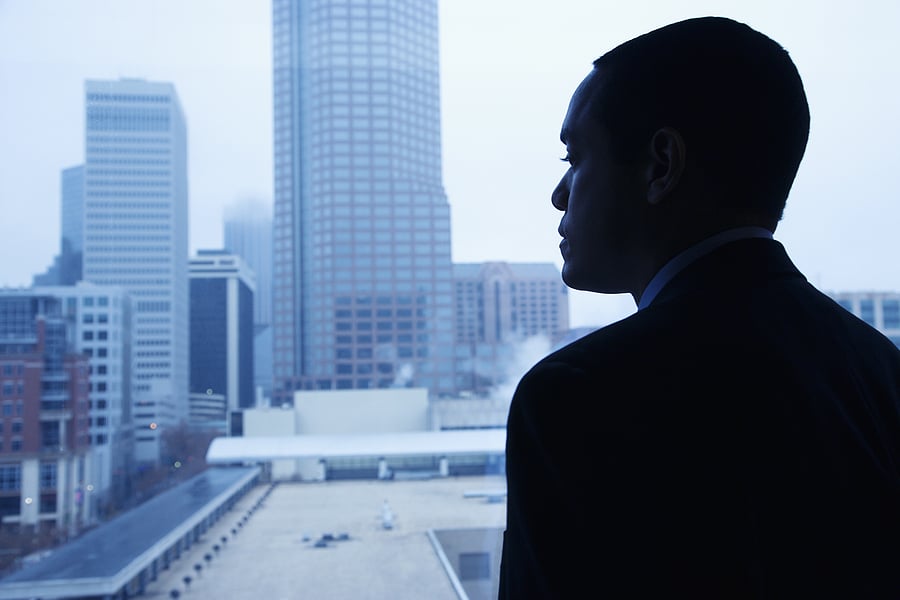 Silhouette of a businessman looking out at the city skyline