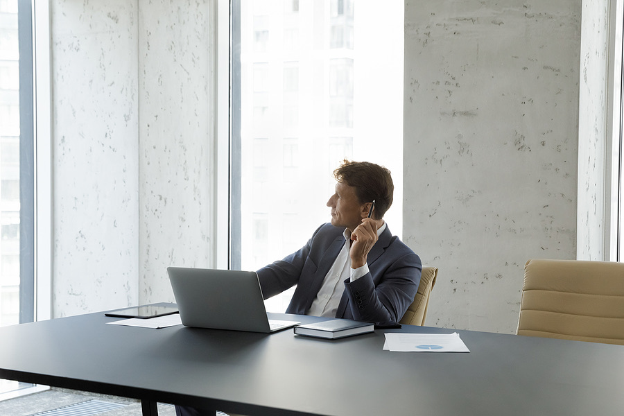 Businessman sitting at a conference table looking out the window