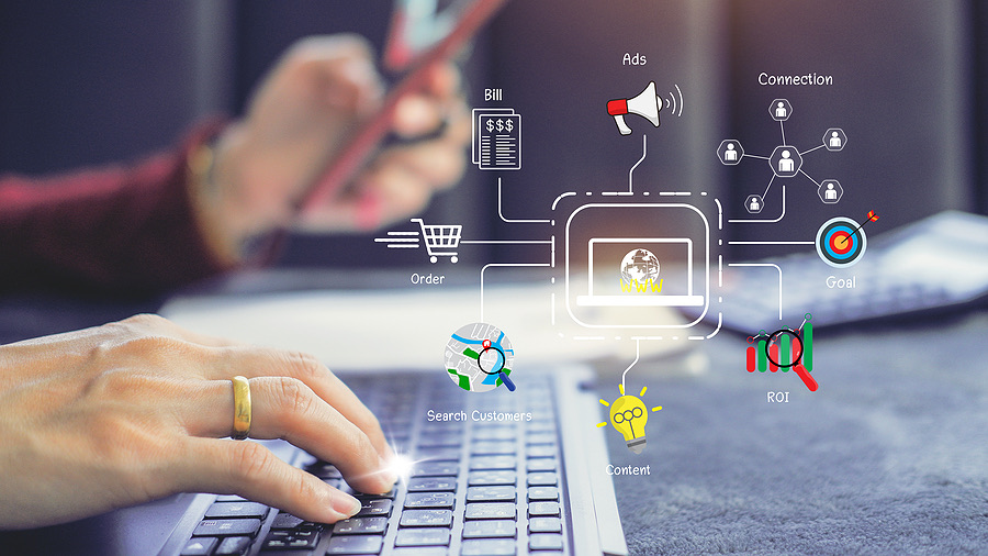 Digital marketing icons overlaid on hands typing at a laptop