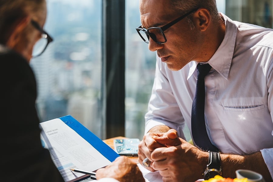Two colleagues reviewing a document together with a city view