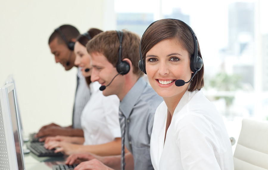 Customer service agents wearing headsets working at computers