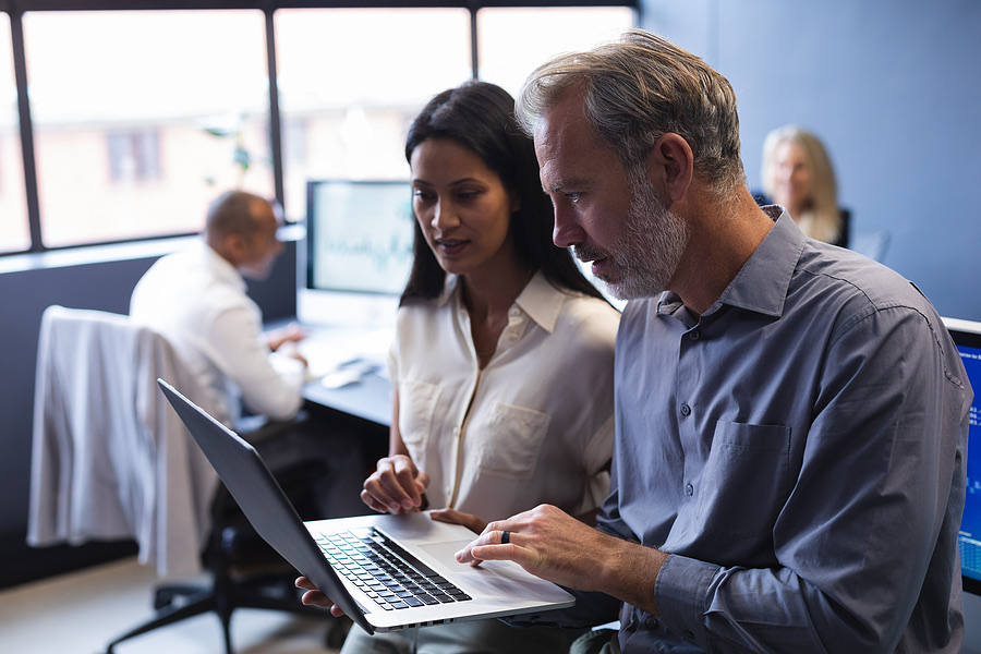 Two colleagues reviewing a laptop together in an office