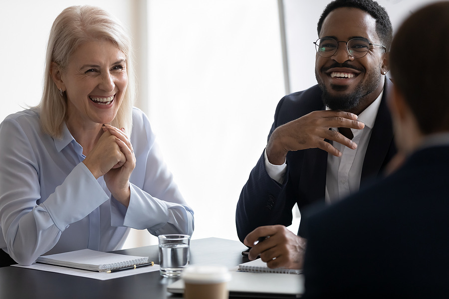 Two colleagues laughing together during a meeting