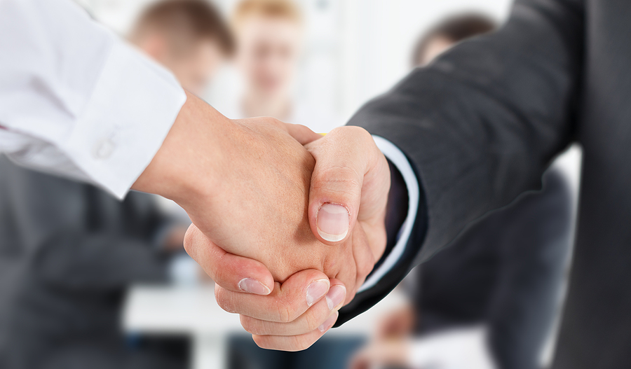 Close-up handshake between two colleagues in an office