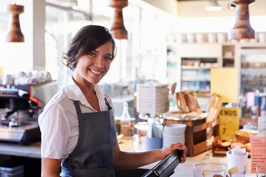 Smiling shop employee standing at a store counter