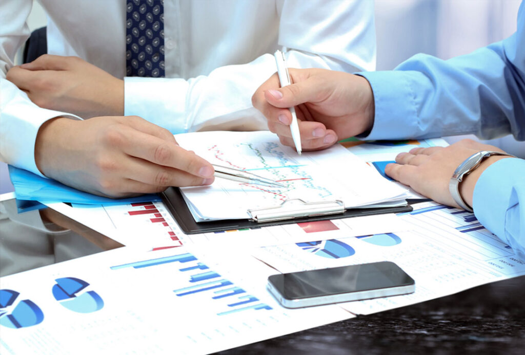 Colleagues reviewing pricing charts and a clipboard