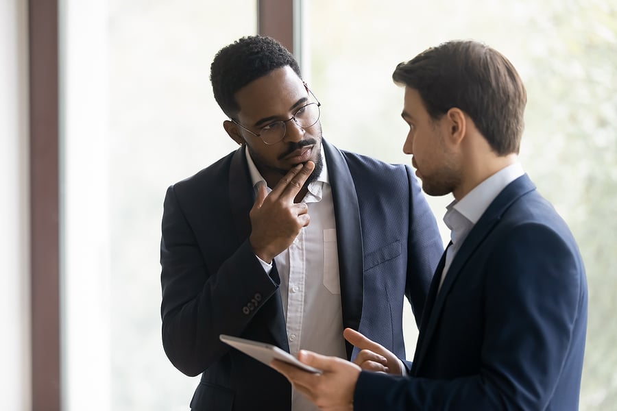 Two businessmen having a serious conversation with a tablet