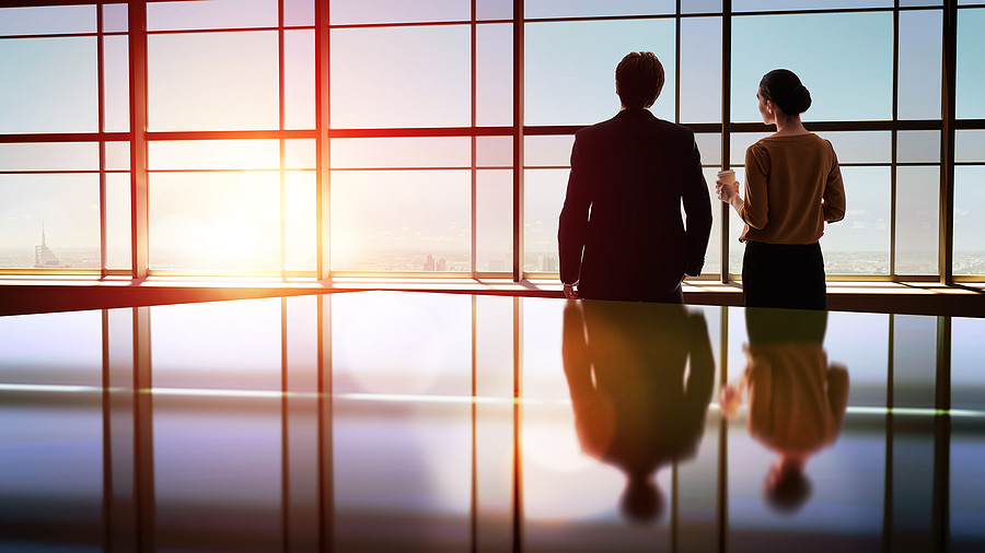 Two colleagues looking out over the city skyline together