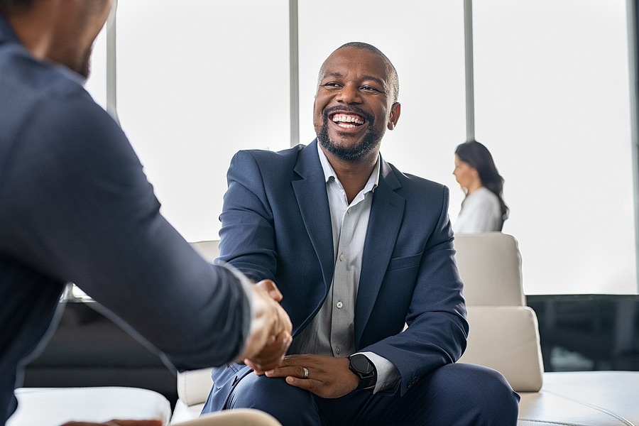 Business owner smiling while shaking hands in an office
