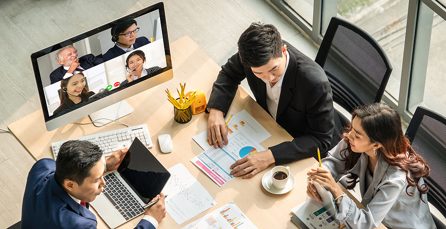 Team meeting with colleagues joining by video call