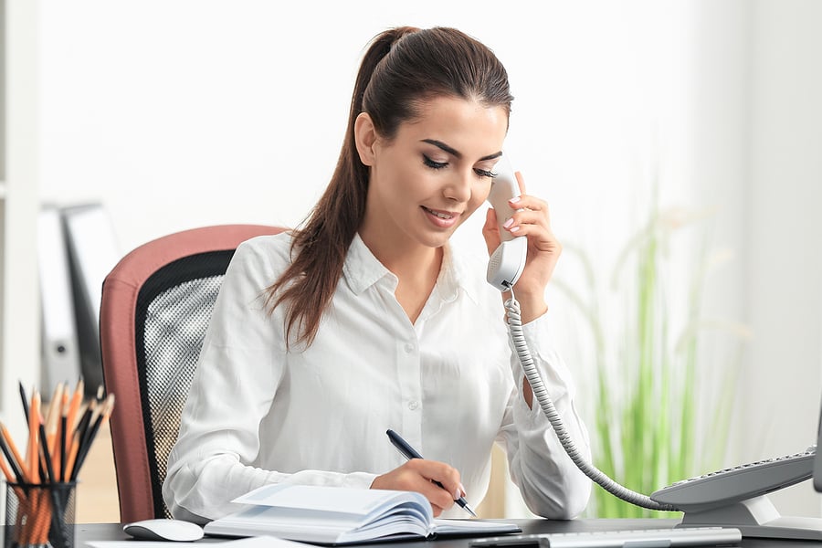 Receptionist taking notes during a phone call