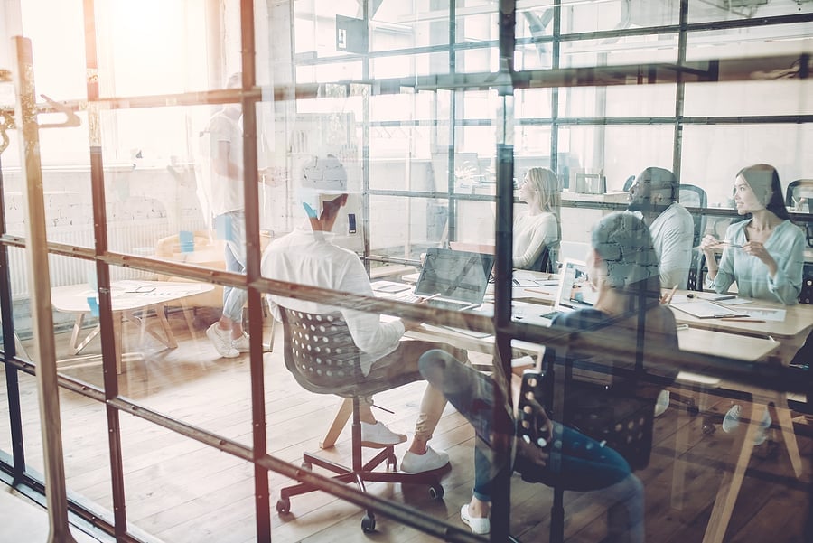 Team working at desks in a modern glass-walled office